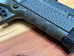 A closer look at the cut Talon Gun Grips piece on the front strap of the author's 1911. Mil-Tac G10 grip slabs cover the ends of the cut piece. A closer look at the cut Talon Gun Grips piece on the front strap of the author's 1911. Mil-Tac G10 grip slabs cover the ends of the cut piece.