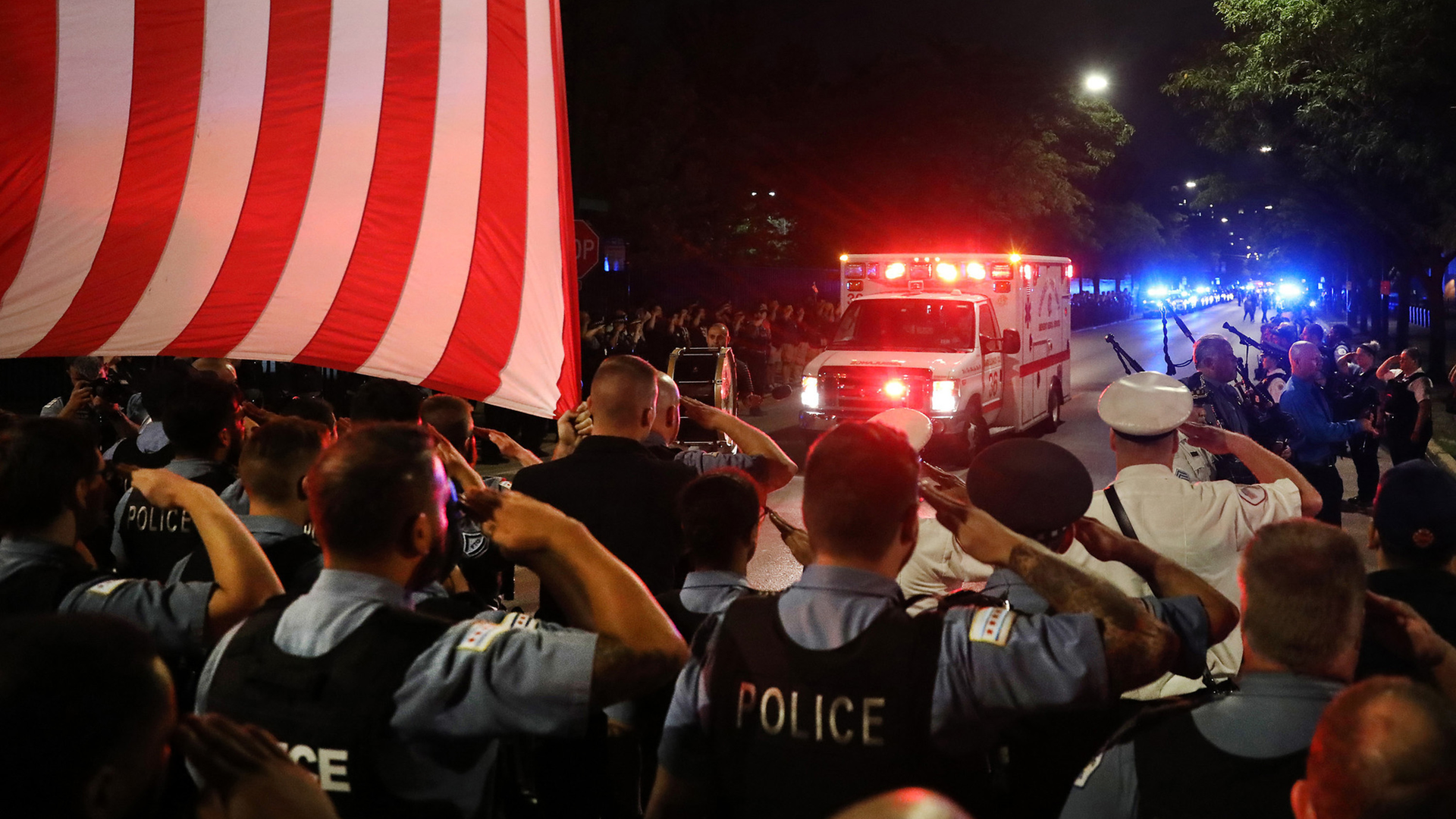 Chicago police officers salute as the ambulance carrying the body of fellow Officer Ella French arrives at the Cook County Medical Examiner in the early Sunday.