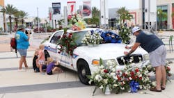 Visitors take the time to sign Daytona Beach, FL, Police Officer Jason Raynor's patrol car in Victory Circle at One Daytona on Friday. Visitors take the time to sign Daytona Beach, FL, Police Officer Jason Raynor's patrol car in Victory Circle at One Daytona on Friday.