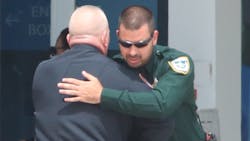 Former Daytona Beach, FL, Police Chief Craig Capri hugs a sheriff's deputy outside the News Journal Center on Sunday during the viewing for slain Officer Jason Raynor. Former Daytona Beach, FL, Police Chief Craig Capri hugs a sheriff's deputy outside the News Journal Center on Sunday during the viewing for slain Officer Jason Raynor.