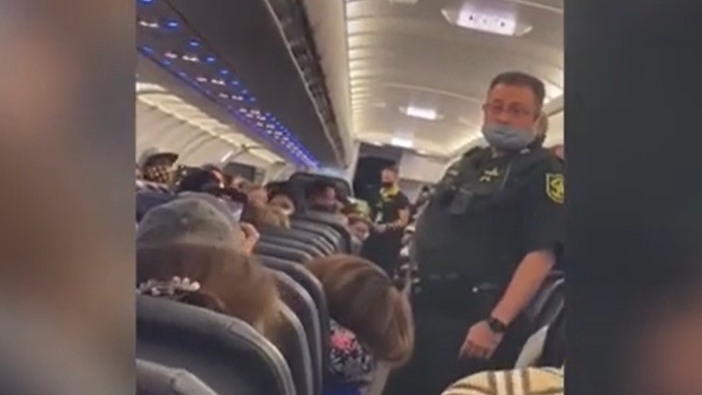 Broward County, FL, sheriff's deputies remove a passenger who lit a cigarette aboard a Spirit Airlines flight Tuesday.
