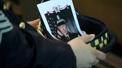 A Chicago police officer holds an image of Officer Ella French in his hat during her funeral service Aug. 19 at St. Rita of Cascia Shrine Chapel.