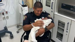 Jersey City, NJ, Police Officer Eduardo Matute cradles a 1-month-old baby he caught after the infant was thrown from a second-story balcony Saturday.