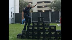 A Miami police officer pretends to try to perform the Milk Crate Challenge in a department video urging the public not to try the online stunt. A Miami police officer pretends to try to perform the Milk Crate Challenge in a department video urging the public not to try the online stunt.