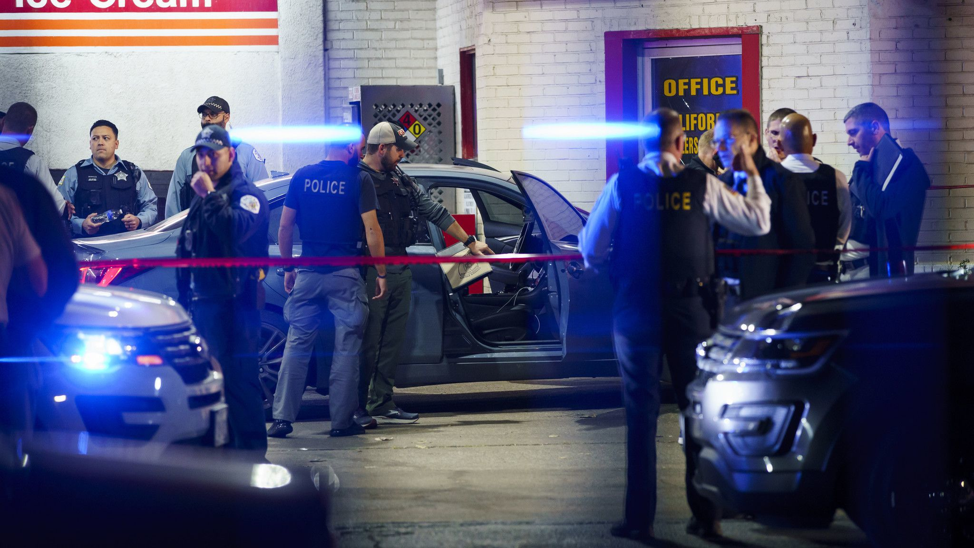 Officers examine a car at the scene where two Chicago police officers were shot on the 8000 block of Ogden Avenue on Wednesday in Lyons.
