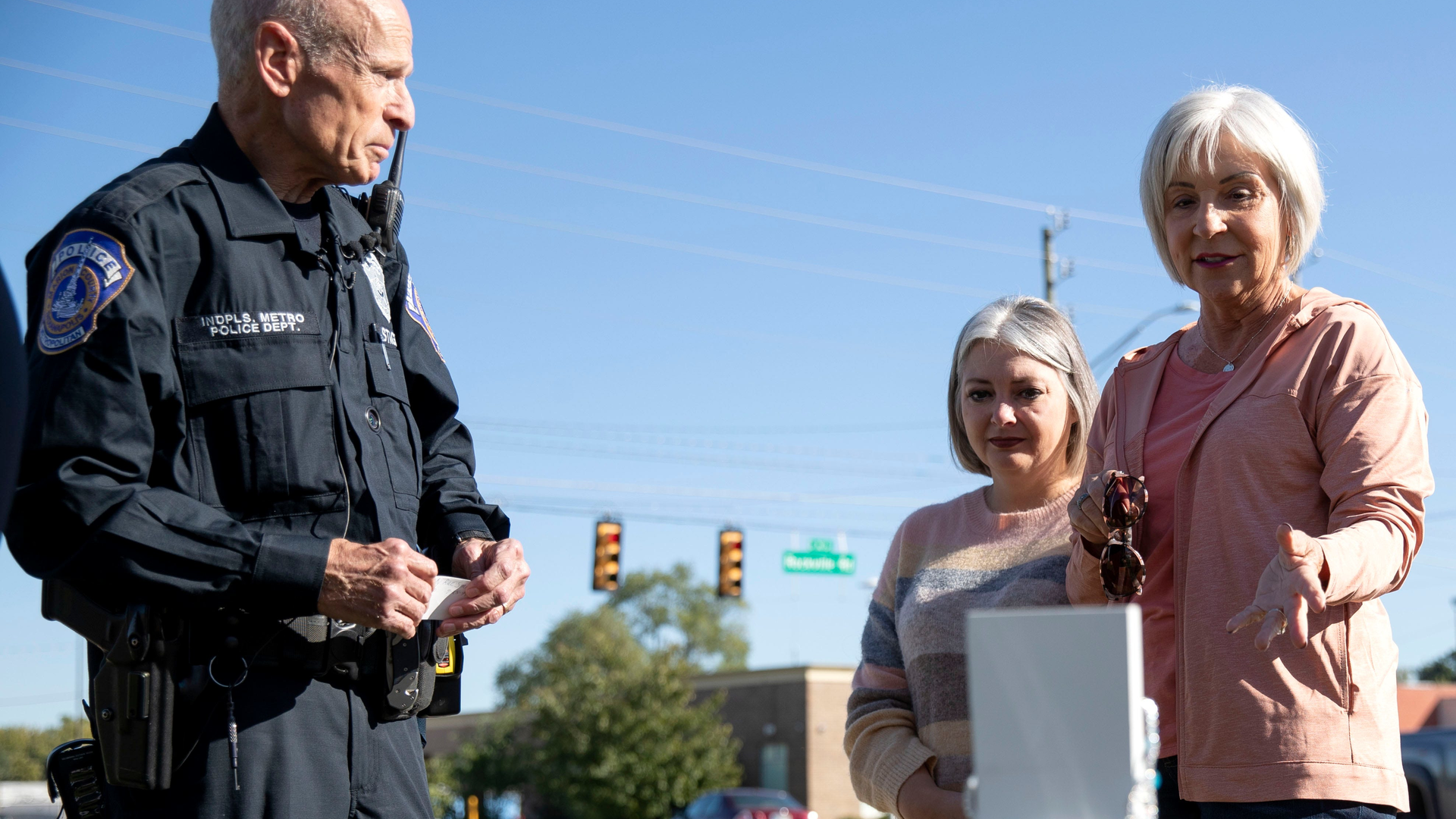 Indianapolis Police Officer Jeff Stagg and Sherri Smith speak after meeting Monday at the intersection of Lynhurst Drive and Rockville Road in Indianapolis. Smith is the mother of Shelby Smith, killed over 20 years ago in a car crash. Stagg saw the memorial for her was getting worn and decided to clean and maintain it. Today, Stagg met Sherri Smith for the first time and showed her the updated memorial for her daughter.