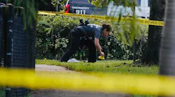 Investigators place yellow evidence markers outside a fence at Mara Berman Guilianti Park in Hollywood, FL, on Monday following the fatal shooting of Officer Yandy Chirino.