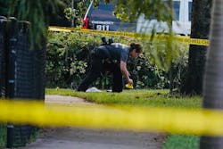 Investigators place yellow evidence markers outside a fence at Mara Berman Guilianti Park in Hollywood, FL, on Monday following the fatal shooting of Officer Yandy Chirino.