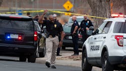 An investigator walks under crime scene tape at the scene of a shooting at Nome Park on Monday in Aurora, CO. An investigator walks under crime scene tape at the scene of a shooting at Nome Park on Monday in Aurora, CO.