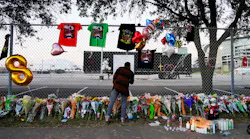 A visitor writes a note at a memorial outside of the canceled Astroworld festival at NRG Park on Sunday in Houston.