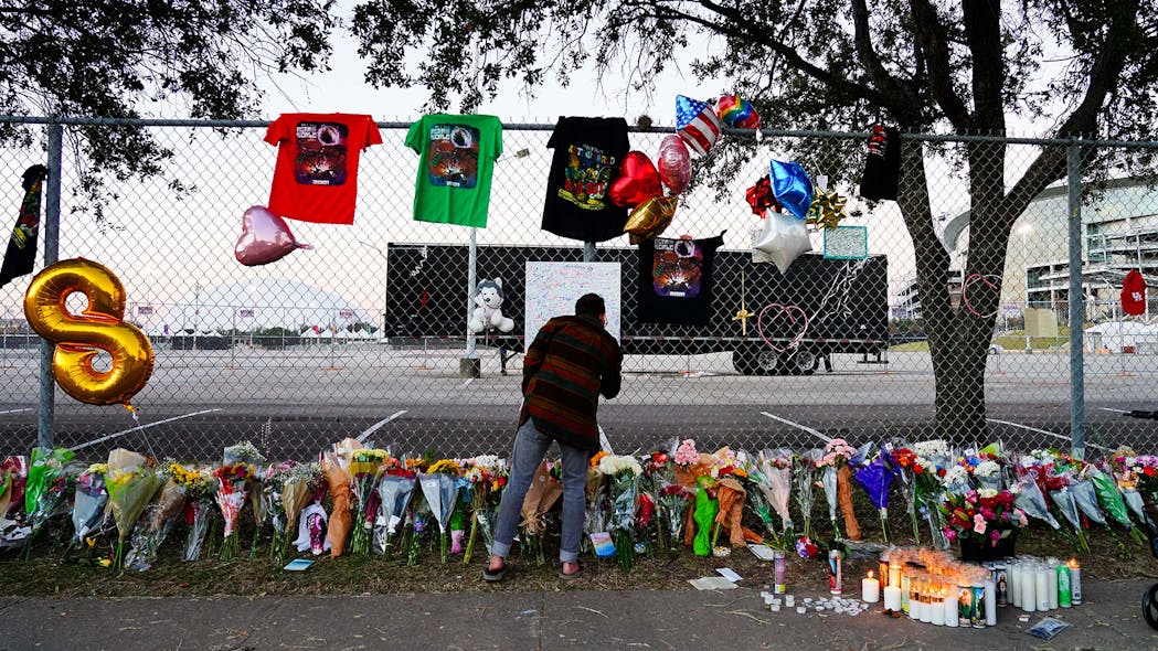 A visitor writes a note at a memorial outside of the canceled Astroworld festival at NRG Park on Sunday in Houston.