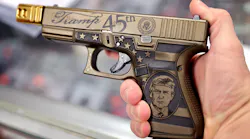 A worker shows off a Glock 19 Donald Trump commemorative 9mm pistol being offered for sale at Freddie Bear Sports in April in Tinley Park, IL.