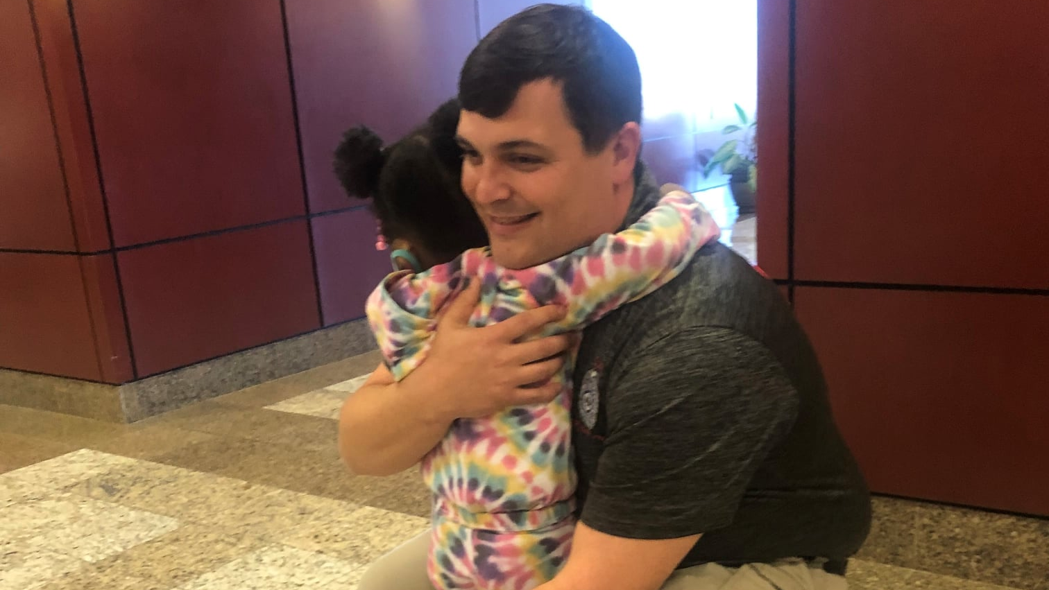 North Charleston, SC, Police Officer Jerrid Riley receives a hug from McKenna Delarosa, who he saved from choking in 2019.