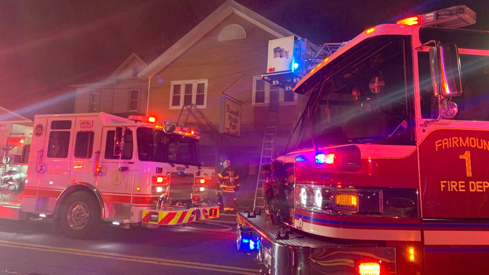 Five police officers from two departments rescued a man in a wheelchair from the second story of a burning building Monday.