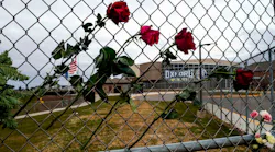 Four roses are placed on a fence outside Oxford, MI, High School to honor the four teens killed in a shooting at the northern Oakland County school Nov. 30.