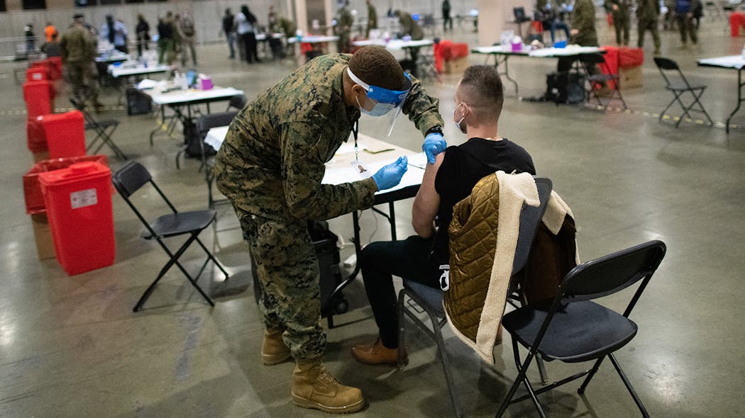 A member of the U.S. military administers a COVID-19 vaccine at a FEMA community vaccination center on March 2 in Philadelphia.