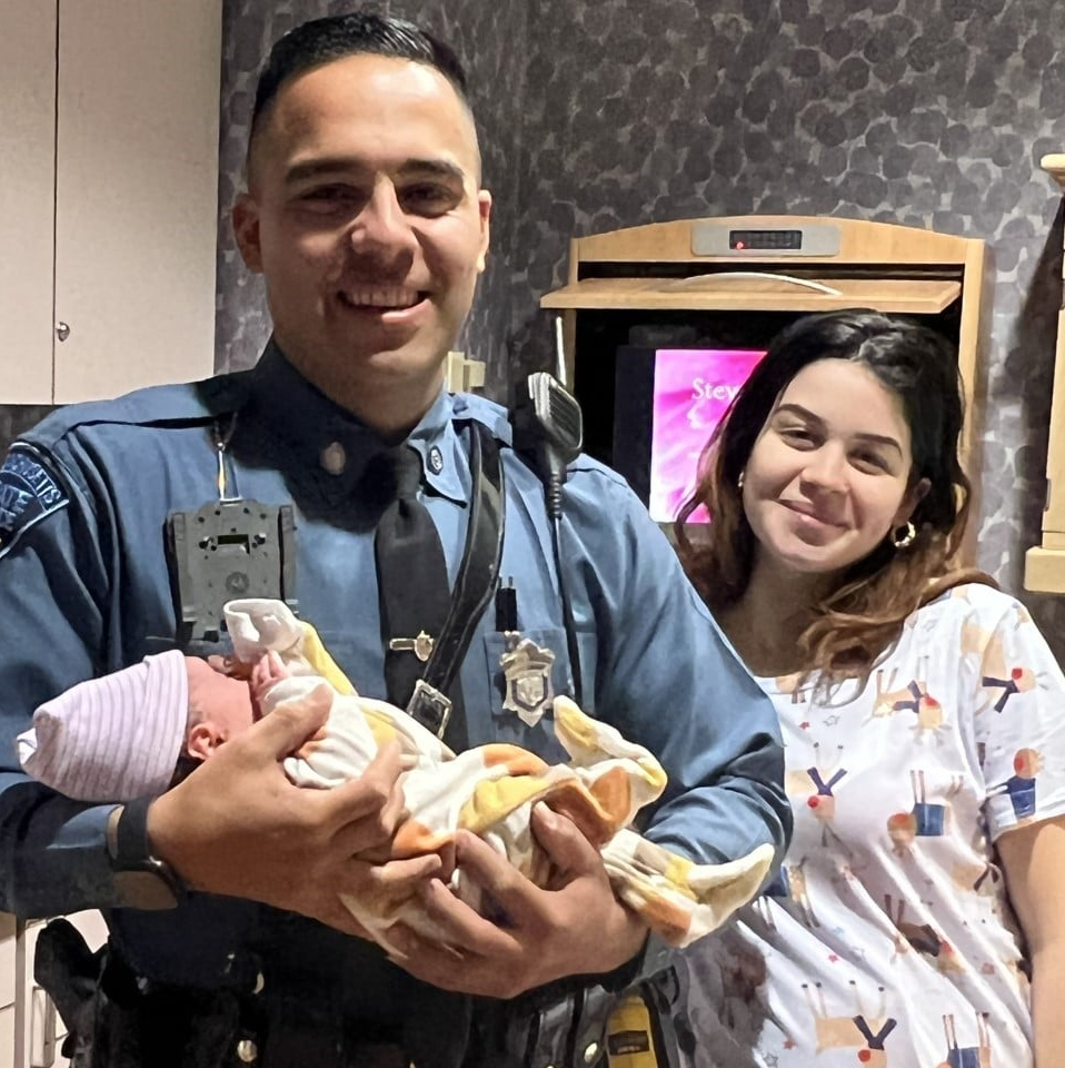 Massachusetts State Police Trooper Jose Cabrera holds the newborn baby boy who was delivered Wednesday after Cabrera rushed the expecting mom to the hospital following a traffic stop in West Springfield.