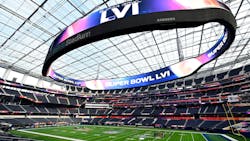 Crews work on the field preparation for Super Bowl LVI as the Oculus video board glows above them on Tuesday at SoFi Stadium in Inglewood, CA.
