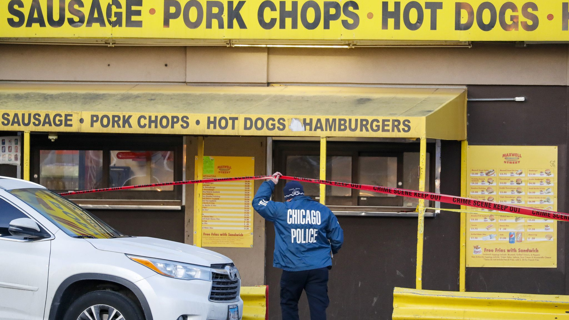 A man is accused of shooting and wounding two Chicago police officers at a hot dog stand Friday after his gun fell out of his waistband while he was in line.