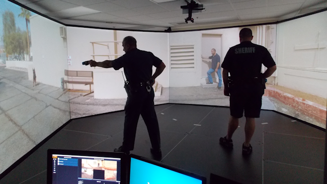 Two officers take part in a Law Enforcement Dog Encounters Training program (LEDET) scenario in VirTra's training simulator.
