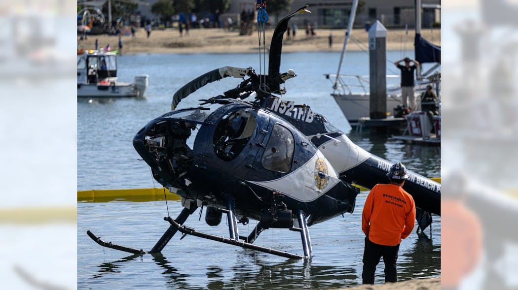 A crane lifts a Huntington Beach, CA, police helicopter out of the water in Newport Beach on Feb. 20. Officer Nicholas Vella, a 14-year veteran of the force, died in the crash the night before.