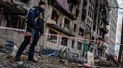 Police officers stand guard outside an apartment building hit by a Russian strike in suburban Kyiv, Ukraine, on Monday.