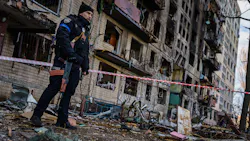 Police officers stand guard outside an apartment building hit by a Russian strike in suburban Kyiv, Ukraine, on Monday. Police officers stand guard outside an apartment building hit by a Russian strike in suburban Kyiv, Ukraine, on Monday.
