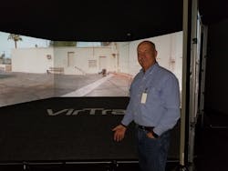 Jim Crosby, who helped develop the Law Enforcement Dog Encounters Training program (LEDET), stands in front of a scenario on VirTra&apos;s training simulator.