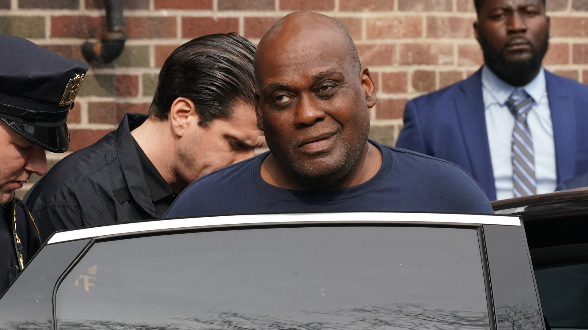 Frank James, 62, is led away by authorities Wednesday after he was arrested on the in Manhattan by two NYPD officers.