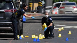 Sacramento police crime scene investigators place evidence markers at the scene of a mass shooting that left six people dead and 12 injured early Sunday.