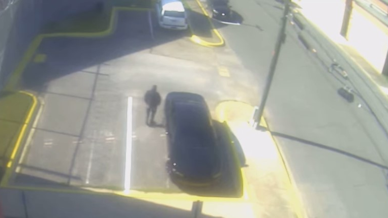 The chief deputy for the Walker County, AL, Sheriff's Office is seen in security camera footage spotting a man allegedly tying a drug-filled sock to the fence of the jail Tuesday.