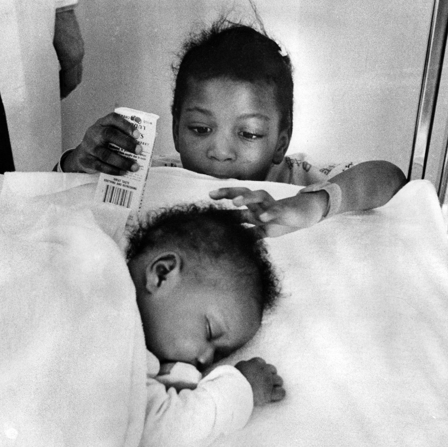 The children of Elizabeth Dunlap: Tara, age 4, looks at her sister, Tenille, 6-weeks old, at Loyola University Hospital on Jan. 4, 1977. They were recovering from exposure after they were found huddled next to their mother's body the previous week.