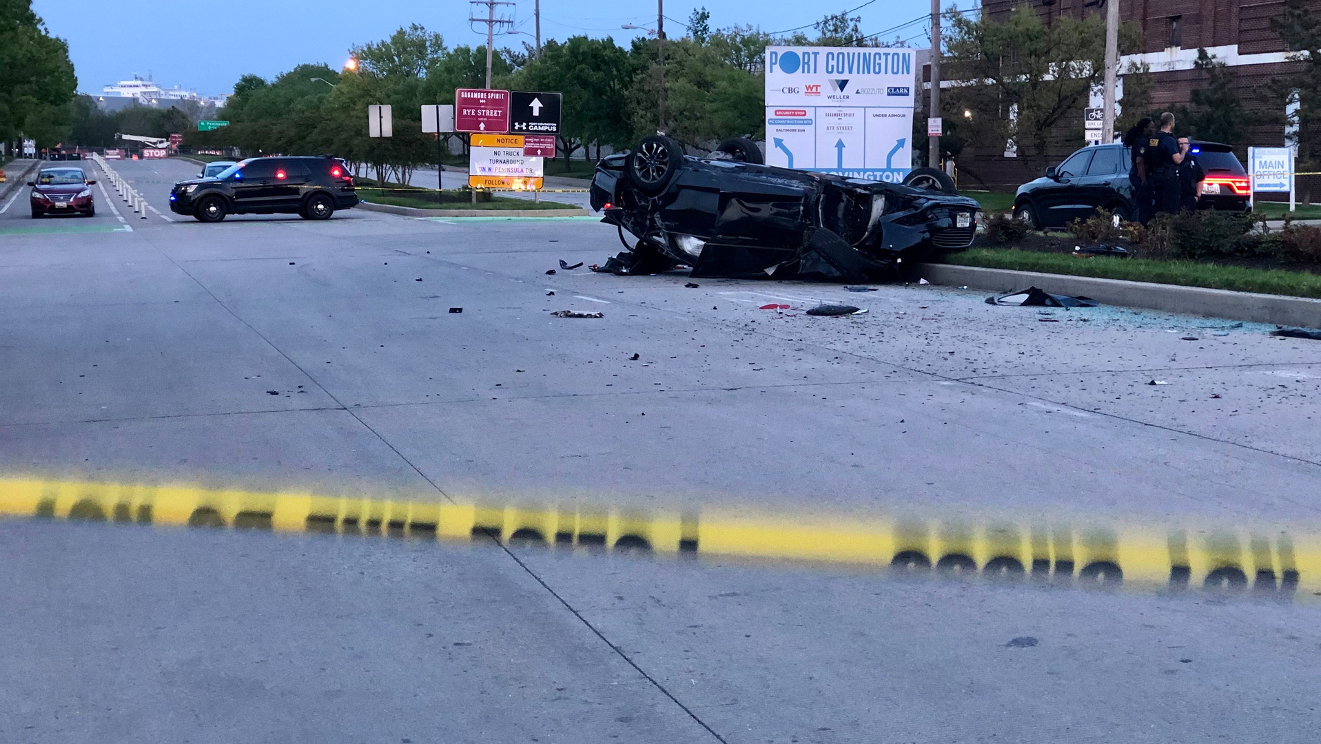 A Baltimore police detective's unmarked car was carjacked by three suspects outside a strip mall before it was involved in a rollover crash Tuesday.