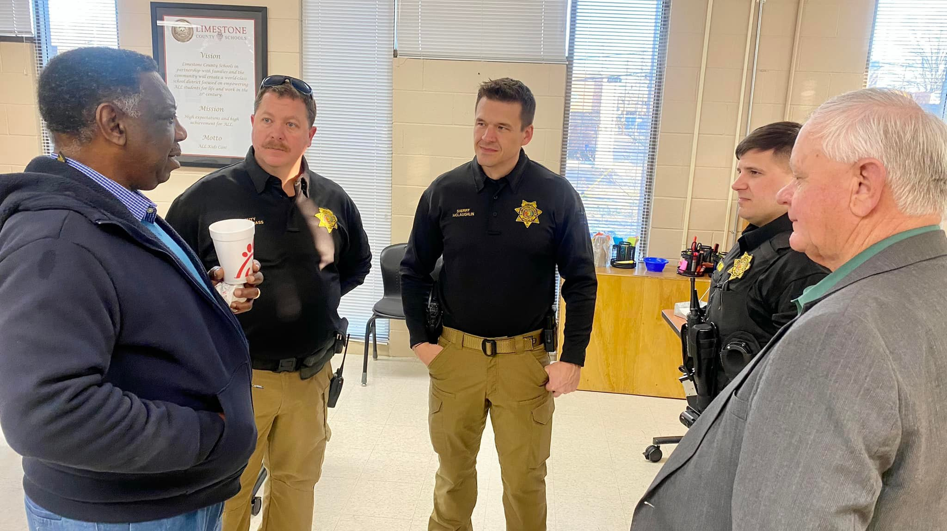 Limestone County, AL, Sheriff Joshua McLaughlin (center) and School Resource Officers Jason Pendergrass (left) and Caleb King talk with county officials during School Resource Officer Appreciation Day in February.