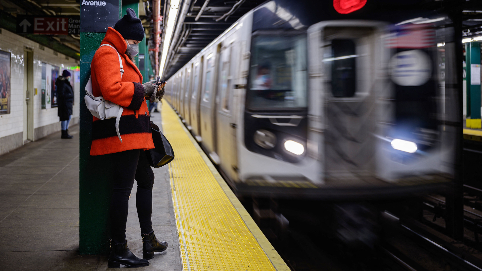 A commuter waits for a subway train at a station in New York City in 2021.