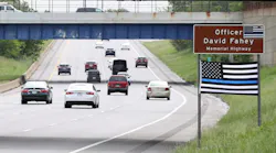 A Thin Blue Line flag hangs below the sign honoring fallen Cleveland Police Officer David Fahey, who was killed in the line of duty along this stretch of Interstate 90 in 2017.