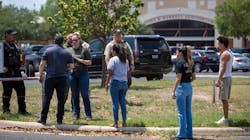 A law enforcement officer tells people Tuesday that Uvalde, TX, High School is secure after a school shooting at the nearby Robb Elementary School.