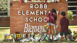 Family members who lost a sibling place flowers outside Robb Elementary School in Uvalde, Texas, on Wednesday, a day after a teen gunman killed 19 students and two teachers.