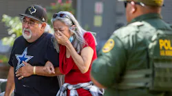 A woman cries Tuesday as she leaves the Uvalde, TX, Civic Center. At least 14 students and a teacher were killed when a gunman opened fire at Robb Elementary School.