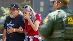 A woman cries Tuesday as she leaves the Uvalde, TX, Civic Center. At least 14 students and a teacher were killed when a gunman opened fire at Robb Elementary School.