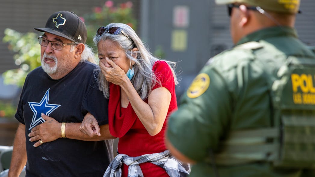 A woman cries Tuesday as she leaves the Uvalde, TX, Civic Center. At least 14 students and a teacher were killed when a gunman opened fire at Robb Elementary School.