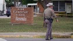 An officer walks outside of Robb Elementary School in Uvalde, TX, on Tuesday after an 18-year-old gunman killed 19 children and two adults at the school in the nation&apos;s deadliest school shooting in years.