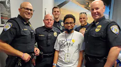 ShaRonda Young Calderon's son, Omarrion, is seen with a group of Frisco, Texas police officers during Camp April.