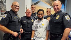 ShaRonda Young Calderon&apos;s son, Omarrion, is seen with a group of Frisco, Texas police officers during Camp April.