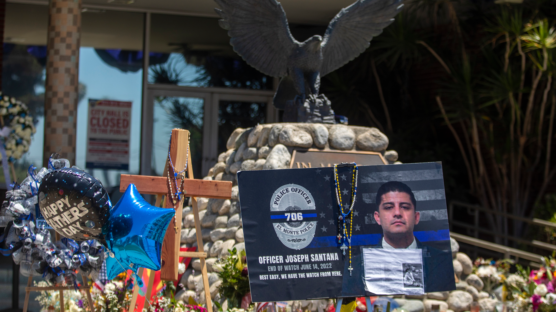People continue to drop by El Monte, CA, Police Department headquarters and look at flowers, flags and balloons left outside in memory of the two officers slain earlier this month.
