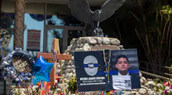 People continue to drop by El Monte, CA, Police Department headquarters and look at flowers, flags and balloons left outside in memory of the two officers slain earlier this month.