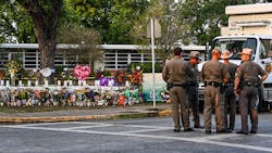 Police officers speak near a makeshift memorial for the shooting victims outside Robb Elementary School in Uvalde, TX, on May 27. Police officers speak near a makeshift memorial for the shooting victims outside Robb Elementary School in Uvalde, TX, on May 27.