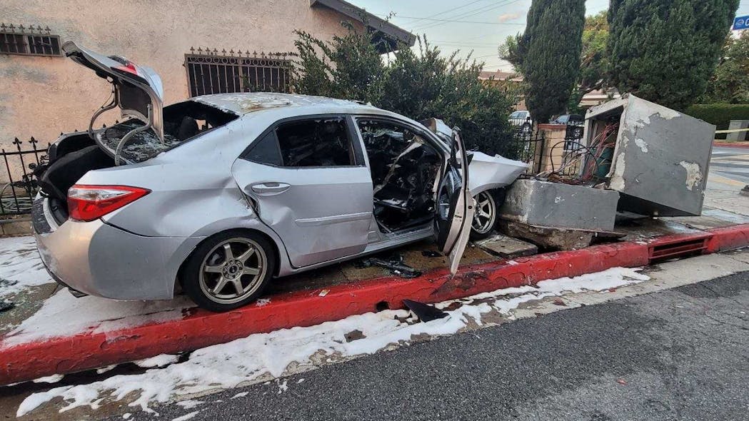 Bell Gardens, CA, police officers rescued a severely burned woman who was trapped in a car that caught fire after crashing into electrical wiring Saturday.