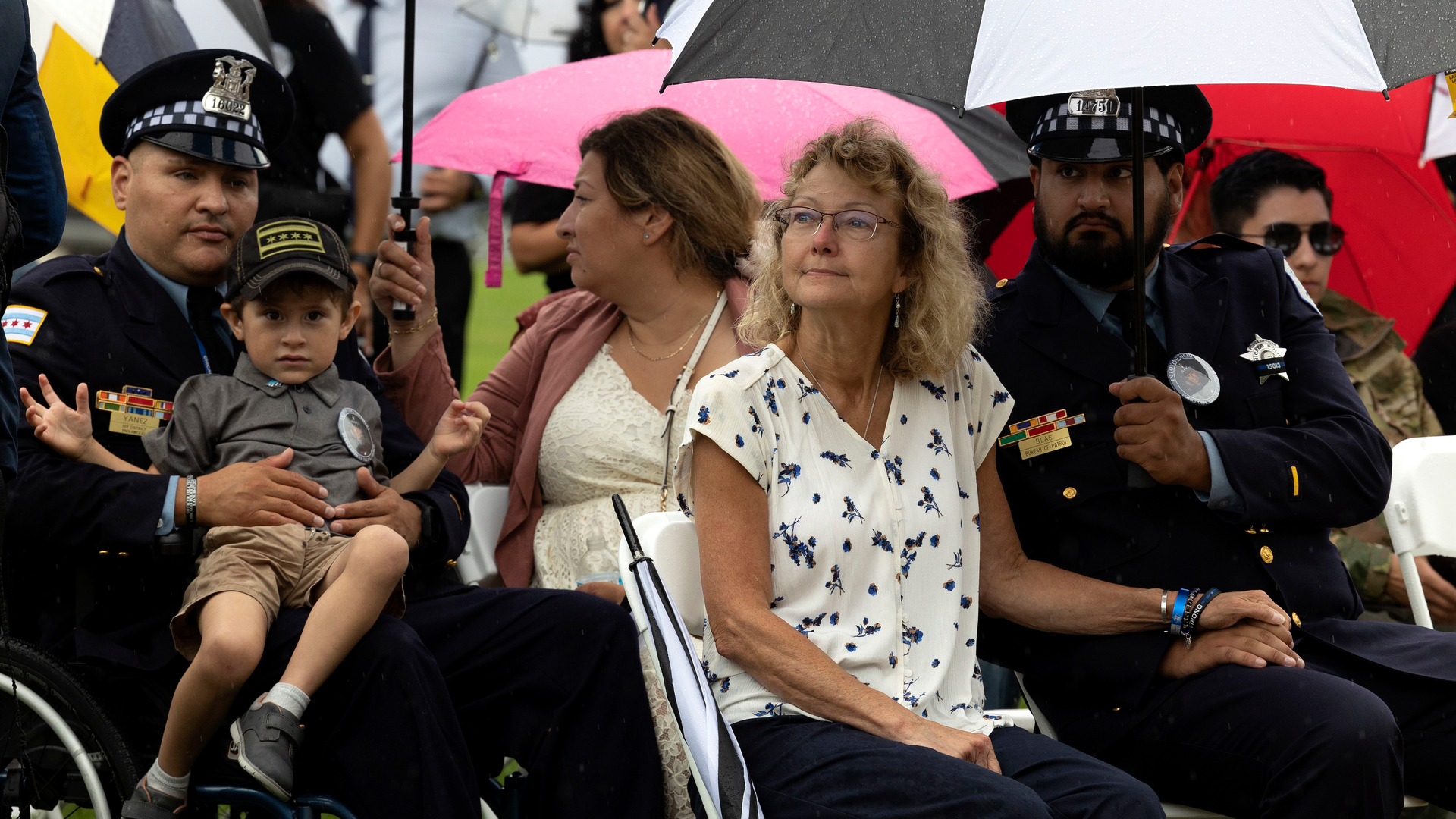 Elizabeth French sits with Chicago Police Officer Joshua Blas and Officer Carlos Yanez Jr. and his family during a memorial service Sunday marking one year since her daughter, Officer Ella French, was killed in the line of duty during a traffic stop.