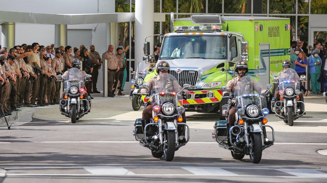 Motorcycle officers escort Miami-Dade Police Det. Cesar Echaverry from Jackson Memorial Hospital to the Miami-Dade County Medical Examiner's Department.